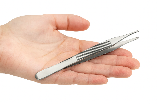 Metal tweezers held in a hand on a white background