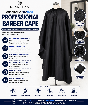 A promotional infographic for the Dhanishka ProEdge Professional Barber Cape, showing the black cape displayed on a mannequin torso against a blurred salon background. The graphic includes feature callouts, circular close-ups of the fabric and snap button, and usage icons for hair cutting, beard trimming, hair styling, salon use, hair coloring, and home use.